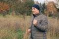 Old positive man in a hat with a smile plays sports, runs in nature, the concept of a healthy lifestyle and sport, close-up