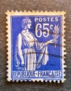 Old postage stamp from France circa 1937 shows a women with an olive branch - peace