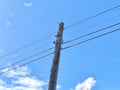 Old power line pole against blue sky in sunny day Royalty Free Stock Photo