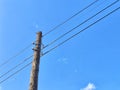 Old power line pole against blue sky in sunny day Royalty Free Stock Photo