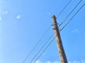 Old power line pole against blue sky in sunny day Royalty Free Stock Photo