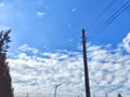 Old power line pole against blue sky in sunny day Royalty Free Stock Photo