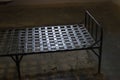 An old prison bed made of forged iron strips, standing in a single cell of the Trubetskoy Bastion prison