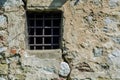 Old prison window in castle cell wall with metal bars Royalty Free Stock Photo