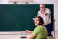 Old professor physicist and young student in the classroom