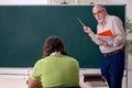 Old professor physicist and young student in the classroom