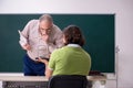 Old professor physicist and young student in the classroom