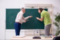 Old professor physicist and young student in the classroom