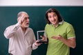 Old professor physicist and young student in the classroom