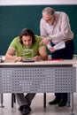 Old professor physicist and young student in the classroom