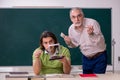 Old professor physicist and young student in the classroom