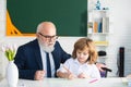 Old professor or senior teacher teaching little school boy. Educational conversation. Talking to students or pupils Royalty Free Stock Photo