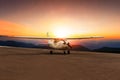 Old propeller plane taxi on airport runway against beautiful sun set sky Royalty Free Stock Photo