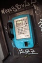 Old public blue payphone, urban mood, graffiti buzz text Royalty Free Stock Photo