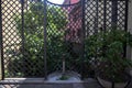 Old public fountain in front of a fence with a row of houses Royalty Free Stock Photo