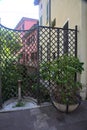 Old public fountain in front of a fence with a row of houses Royalty Free Stock Photo