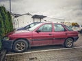 Old purple red private car Ford Escort parked