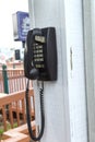 an old push-button telephone hangs on a white wall on the wall Royalty Free Stock Photo