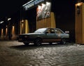 Old racing car standing by the night garage Royalty Free Stock Photo