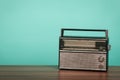 Old radio on table in front of green background. Vintage style photo Royalty Free Stock Photo