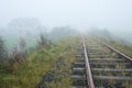 Old railroad and house vanishing in fog