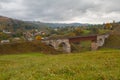 Old railway bridge and mountain village. Carpathians