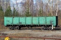 Old railway freight car of green color on the siding