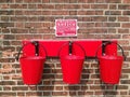 Old railway red fire buckets with a notice on a brick wall