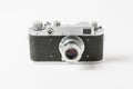 Old rangefinder vintage camera against white background with small lens. Range finder photo camera with lens. Classic