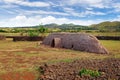 Old Rapa Nui thatch-roofed house at the ceremonial center of Vaihu, on Easer Island, against a blue sky covered by white