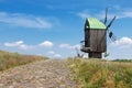 Old Rare Ancient Wooden Windmill with Stone Block Road in front of Cloud Sky Royalty Free Stock Photo