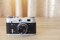 Old rare Soviet Russian photo camera with lens on brown wooden background