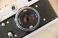 Old rare Soviet Russian photo camera with lens on brown wooden background