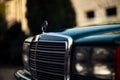 Old rare vintage green Mercedes-Benz hood, badge, glasses, headlights, radiator grille on blurred background Royalty Free Stock Photo