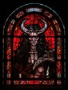 Old Realistic Stained Glass Window with the image of a devil or satan