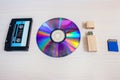 Old recorder cartridge, USB stick, and compact disks in a row Royalty Free Stock Photo