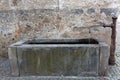 Old rectangle well with running water from fountain tap in Glurns (Glorenza), Italy, Europe. Royalty Free Stock Photo