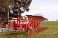 Old red agricultural machine with rust on it, rustic farm equipment Royalty Free Stock Photo