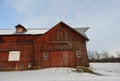 Historic antique red barn after winter snowfall Royalty Free Stock Photo