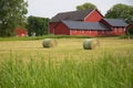 Old red barn with round bales of hay in the foreground