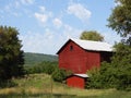 Old wooden red barn in upstate NY countryside field of green Royalty Free Stock Photo