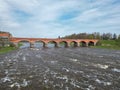 The old red brick bridge across the Venta river. Kuldiga, Latvia Royalty Free Stock Photo