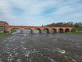 The old red brick bridge across the Venta river. Kuldiga, Latvia Royalty Free Stock Photo