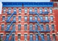 Old red brick building with blue iron fire escapes, New York City, USA Royalty Free Stock Photo