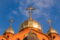 Old red brick Christian church with gold and gilded domes against a blue sky. Concept faith in god, orthodoxy, prayer Royalty Free Stock Photo