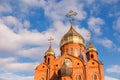 Old red brick Christian church with gold and gilded domes against a blue sky. Concept faith in god, orthodoxy, prayer Royalty Free Stock Photo