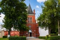 Old red brick church among green trees in Polotsk