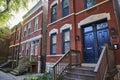 Old red brick house with black doors, and windows in row of three homes, mortgage, finance