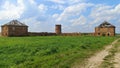 An old red brick house with a round tower with no windows, no doors, and a failing metal roof has long been abandoned. A dirt road Royalty Free Stock Photo