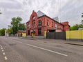 An old red brick mortuary building on a city street.